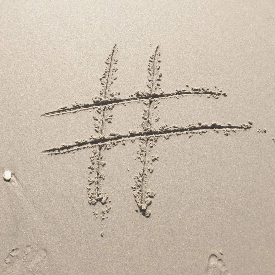 Instagram hashtags tips: hashtag drawn in sand on a beach