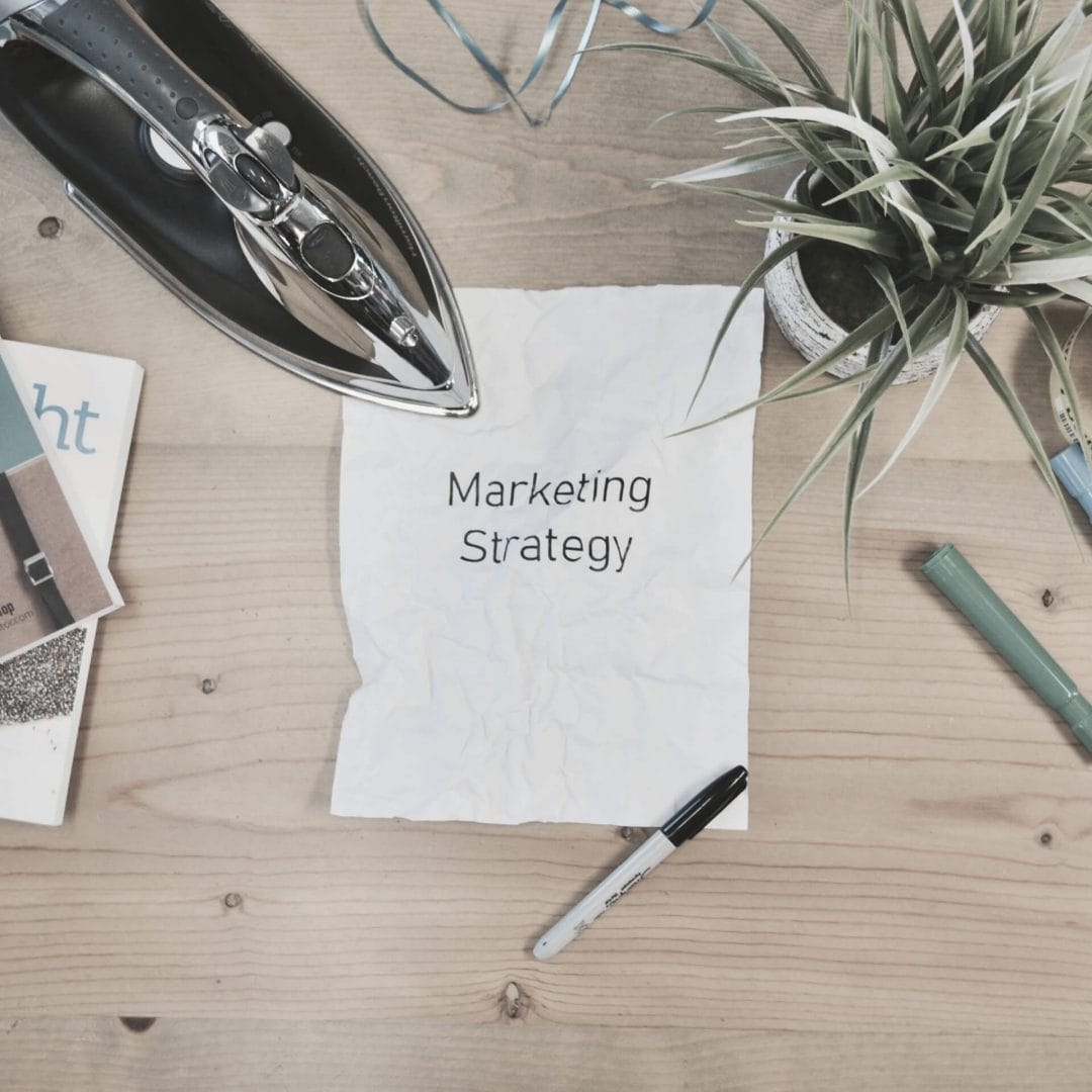 Marketing Basics: crumpled paper on messy desk that reads "marketing strategy"