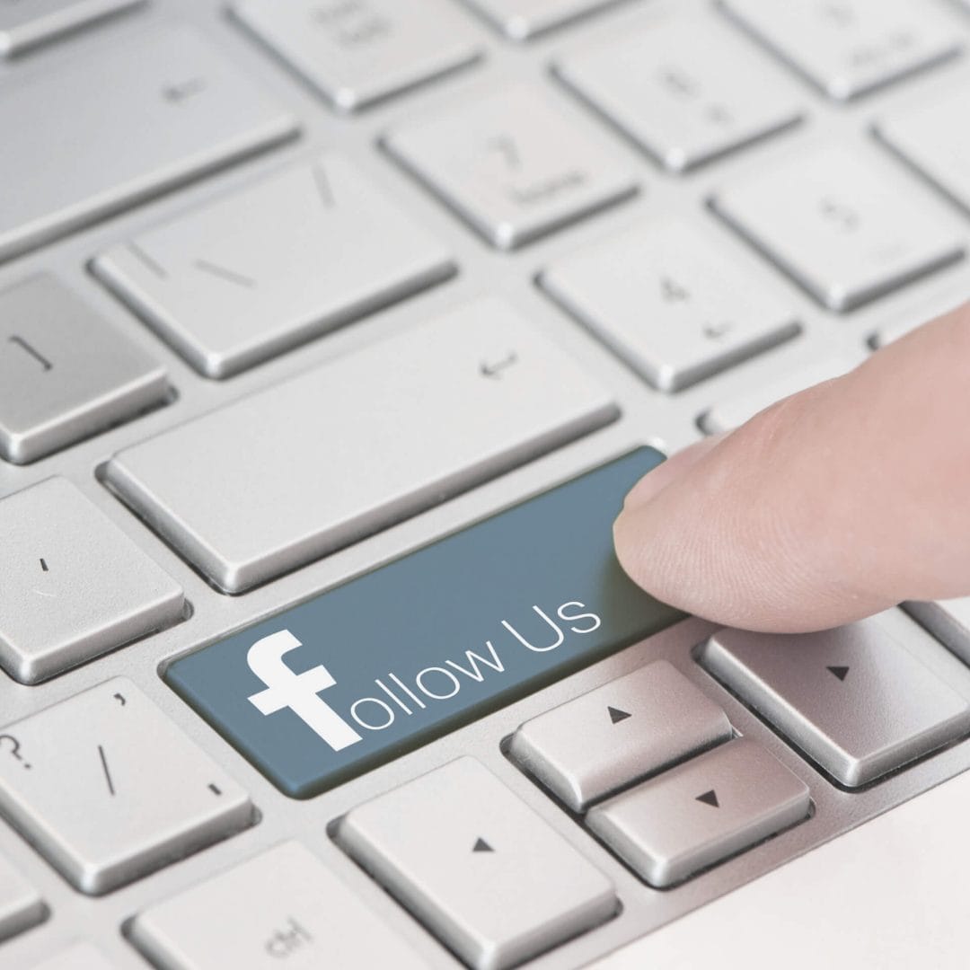 Facebook followers: finger hovering over a keyboard button labeled "follow us"