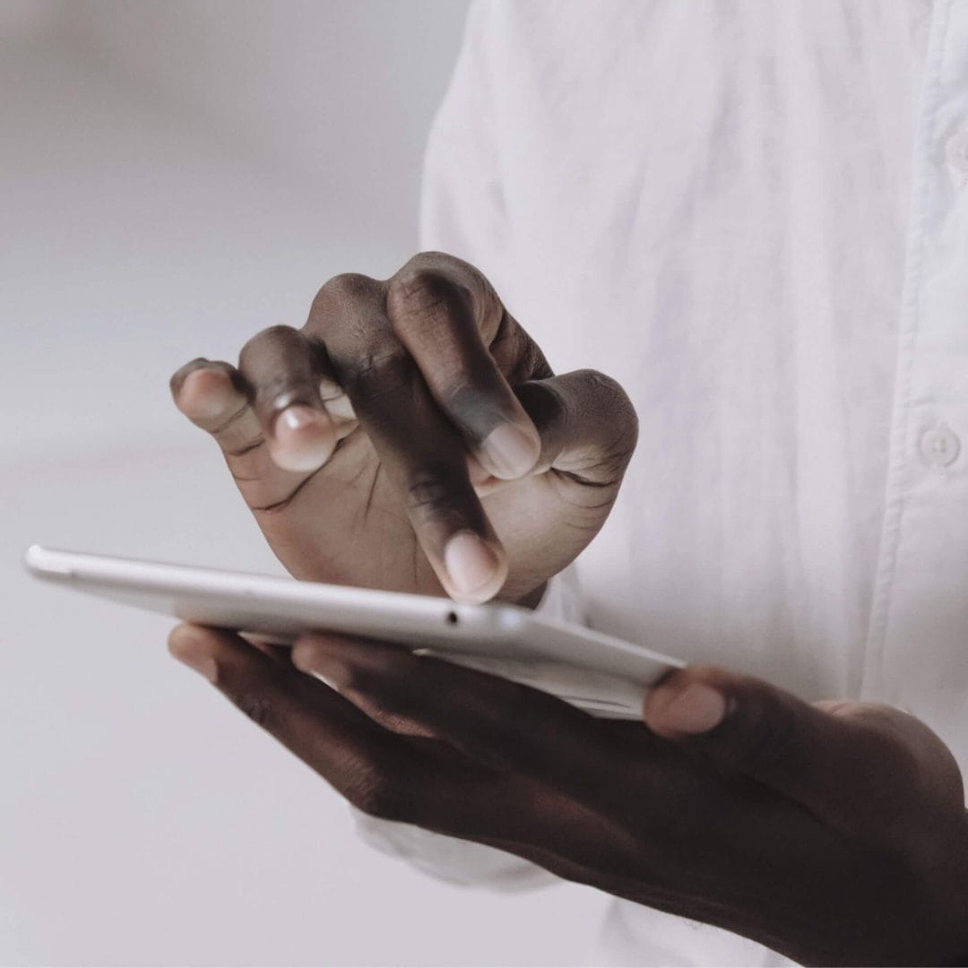 Man's fingers touching a tablet screen during his user experience.